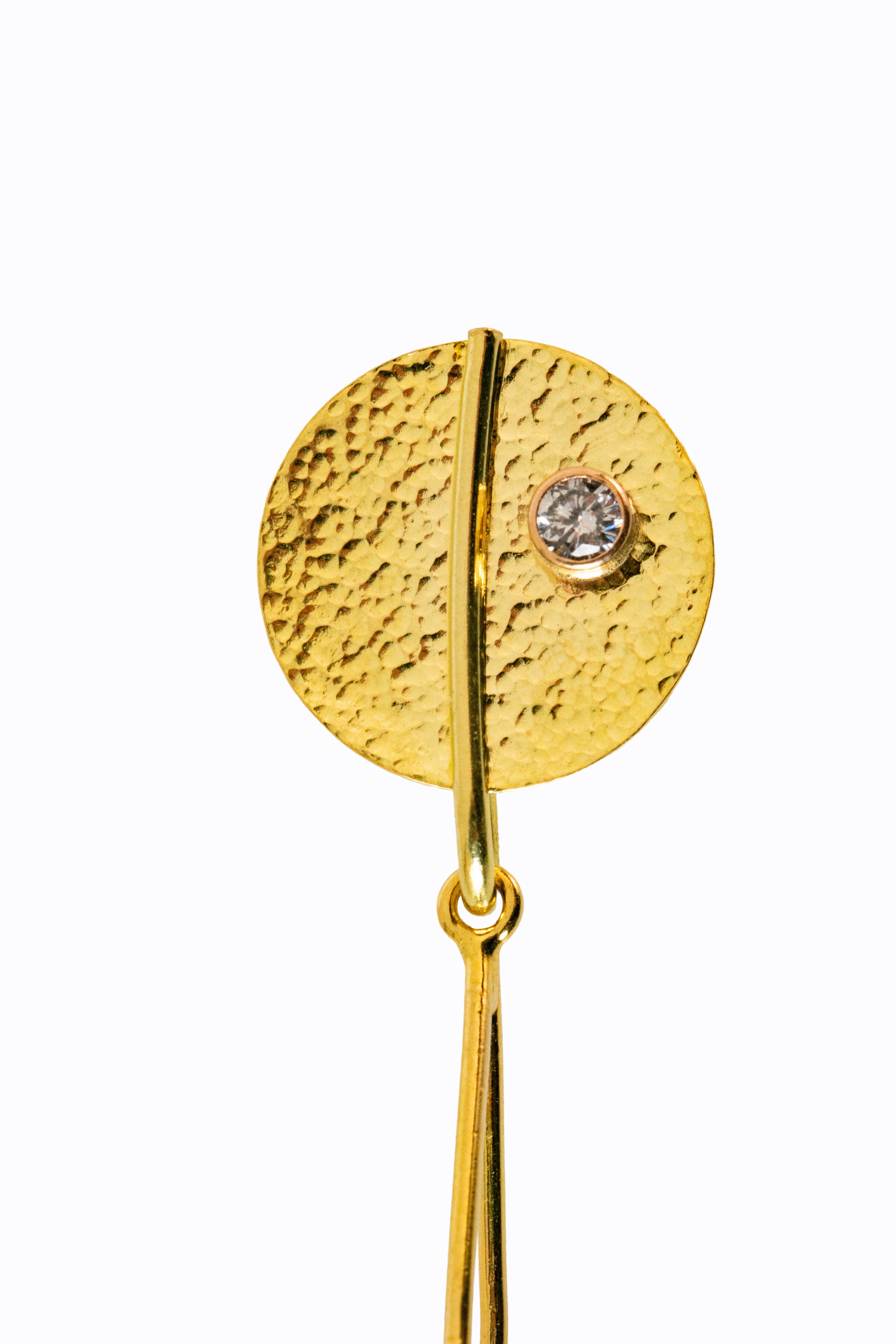 Close-up of Noosa earring 18k hammered gold disc stud with bezel-set diamond detail by Alexandra Essex