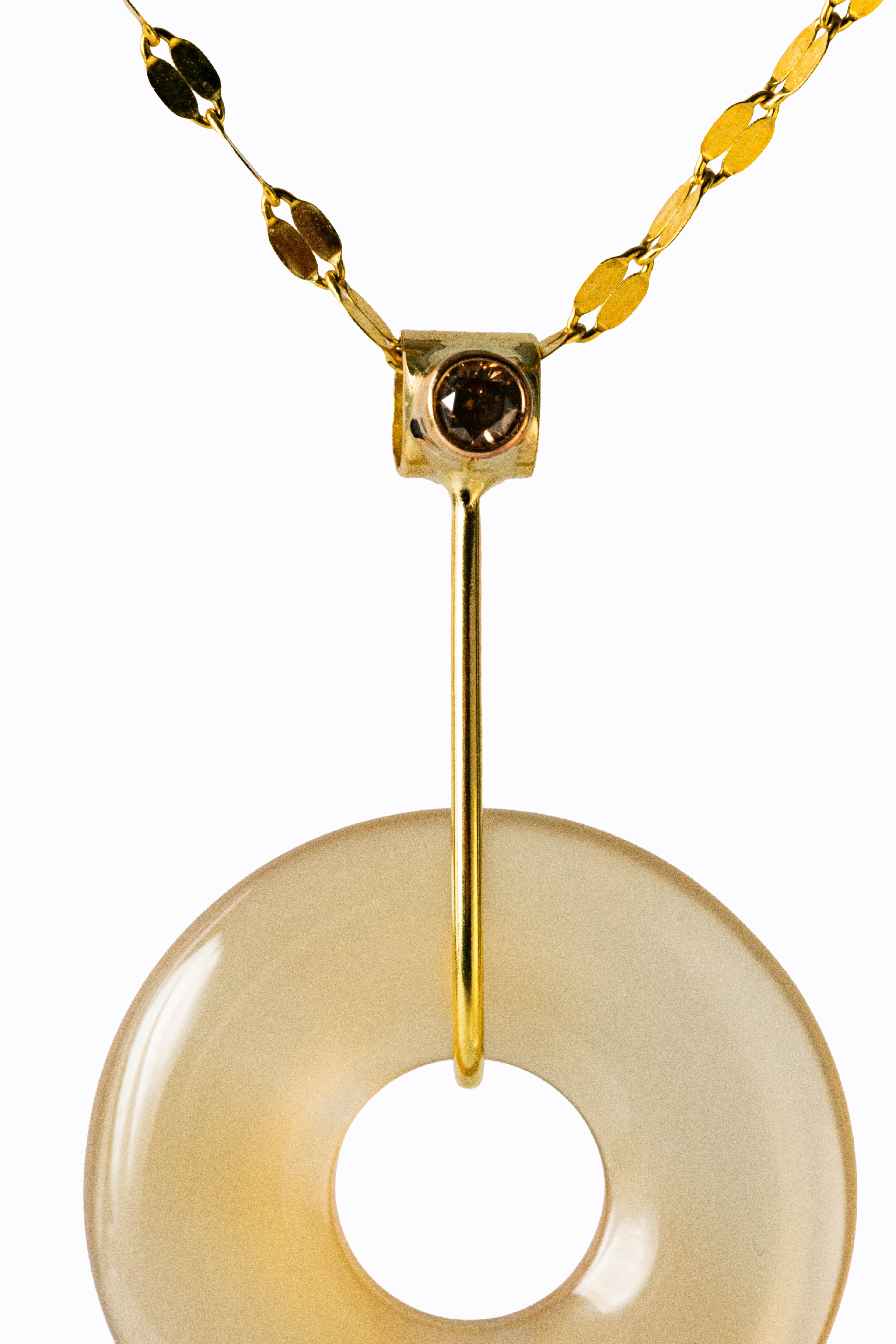 Eclipse moonstone disc pendant close-up showing adularescent white stone with cognac diamond and 18k gold bail by Alexandra Essex