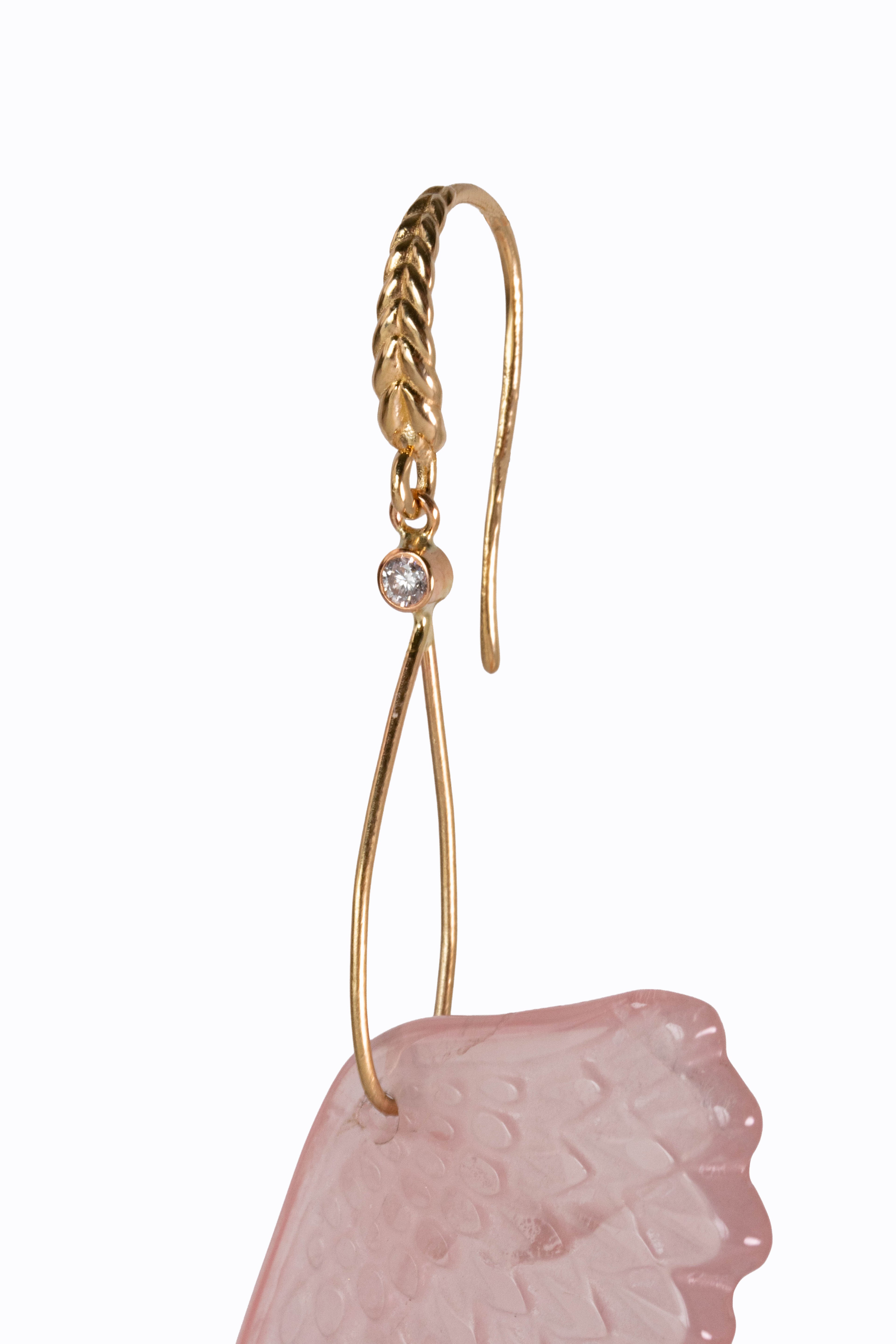 Samothrace earring close-up showing 14k braided gold French hook with bezel-set diamond and carved rose quartz wing detail by Alexandra Essex